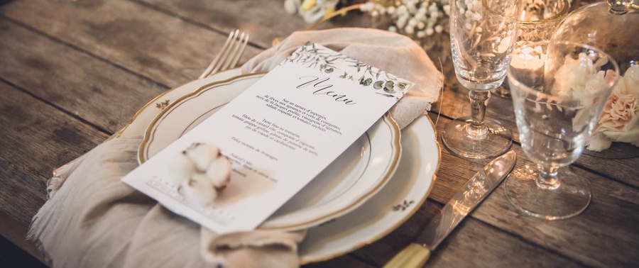 Couvert et menu de mariage sur une table en bois