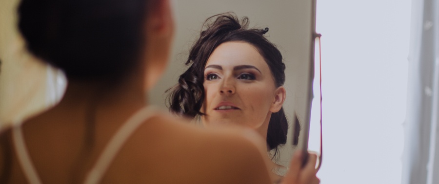 Une mariée se regarde son maquillage dans une glace