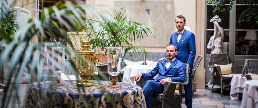 Les deux mariés dans leur costume de mariage bleus, posent pour le photographe